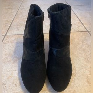 Women’s black suede heeled booties with faux leather trim.